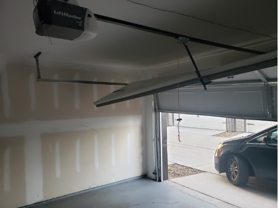 Open garage door with a car outside, featuring a LiftMaster opener from Brentwood Garage Door Services.