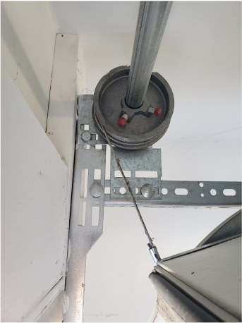 Garage door cable and pulley system, maintained by Brentwood Garage Door Services.