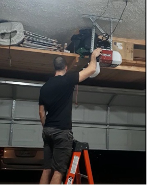 Professional servicing a garage door opener, by Brentwood Garage Door Services.