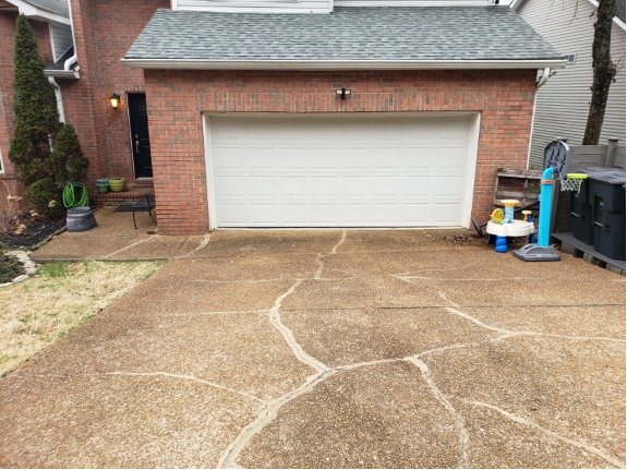 Residential driveway leading to a white garage door before service by Brentwood Garage Door Services.